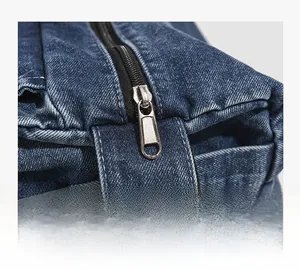 Close-up of high-quality silver metal zipper on vintage blue denim crossbody bag