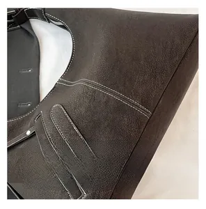 Detail of dark brown tote bag featuring white contrast stitching and silver metal ring