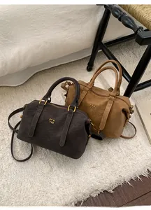 Detail of Boston bags in brown and camel faux leather with gold PAN TOR logos