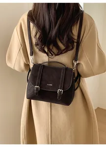Detailed view of coffee brown faux suede messenger bag with silver magnetic buckles