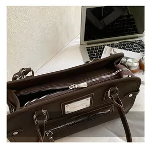 Détail du sac à main rétro en cuir marron dépoli avec fermetures éclair argentées