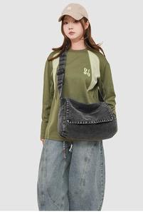 Detail shot of vintage washed denim messenger bag with wide adjustable shoulder strap