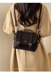 Detail of retro dark matte texture bag with decorative buckles on a wool coat