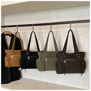 Vista detallada de los bolsos tote en camello, negro, oliva y marrón con textura de gamuza