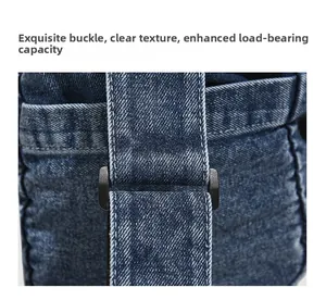 Detailed close-up of a durable plastic adjustment buckle on a denim messenger bag strap