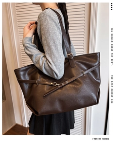 Dettaglio borsa tote vintage marrone scuro con fibbie in metallo e trama in ecopelle