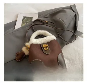 Détail du sac seau en daim marron avec bordure en peluche blanche et fermoir doré chic