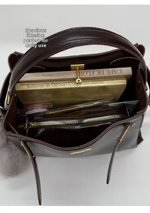 Interior view of brown bucket bag showing large capacity with removable zipper pouch