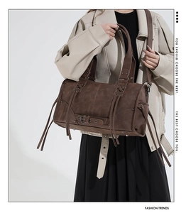 Detail of brown vintage tote bag with fringe and belt buckle in soft faux suede finish