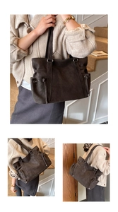 Detalle de bolso tote de ante marrón oscuro con bolsillos laterales y anillas plata