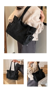 Detalle de bolso tote negro grande con bolsillos laterales de cordón y cuero mate