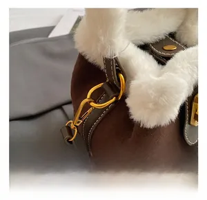 Détail du sac seau en daim marron avec crochet doré et bordure en fausse fourrure