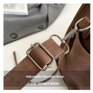 Detail view of the brown leather shoulder bag featuring an adjustable strap and silver metal buckle