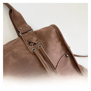 Detail of vintage brown tote bag showing textured material and metal rivet decor