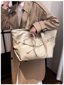 Dettaglio della borsa tote bianco crema con cinturini decorativi e texture in pelle opaca