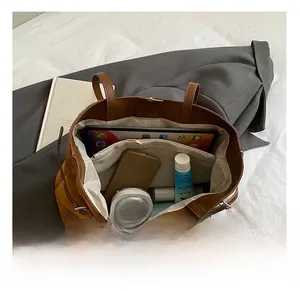 Vue intérieure montrant la grande capacité et les poches du sac cabas en daim brun