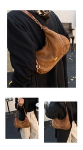 Detail view of brown suede crescent bag with white contrast stitching and gold metal ring