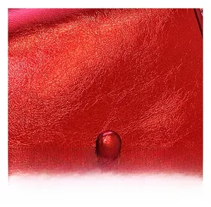 Dettaglio macro della pelle metallizzata rossa con cuciture a doppia fila rifinite