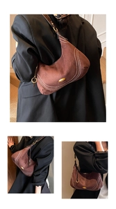 Detail of suede crescent bag showing white contrast stitching and gold metal buckle