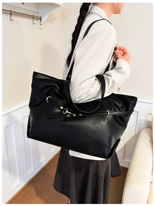 Dettaglio borsa tote in pelle PU nera con anello dorato e design elegante della tracolla