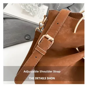 Detail of adjustable shoulder strap and gold hardware on brown bucket bag