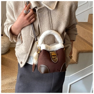 Détail du sac seau en daim marron avec bordure en fausse fourrure blanche et fermoir doré