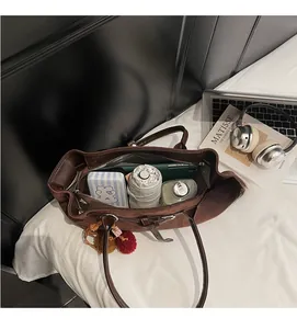 Spacious interior of brown suede tote bag holding umbrella and daily essentials