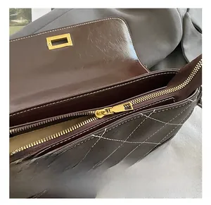 Close-up of retro dark brown quilted handbag featuring gold twist lock and smooth zipper