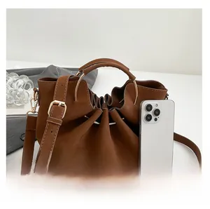 Detail of caramel faux leather tote with drawstring closure and metal ring handle