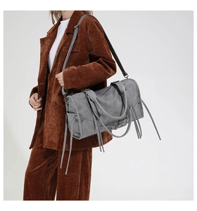 Detail of grey fringe tote bag showing long tassels and matte faux leather texture