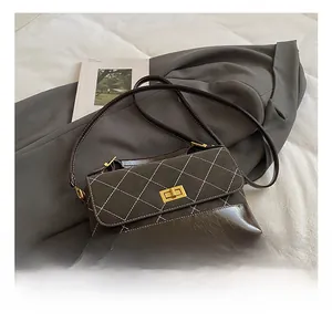 Detail of dark brown quilted shoulder bag with gold square twist lock and white stitching