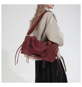 Détail du sac cabas vintage bordeaux avec glands et rivets métalliques pour femme