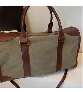 Detail of army green canvas tote with brown leather handles and reinforced stitching