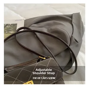 Close-up of matte rhombic texture crossbody bag with gold lock and adjustable strap