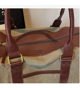 Detail of vintage canvas travel bag with leather trim and embossed brand lettering