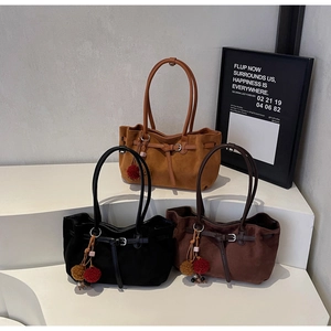 Three minimalist matte suede tote bags in black, coffee, and camel with pompom charms