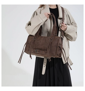 Macro detail of dark brown vintage faux leather tote with rivet and buckle ornaments