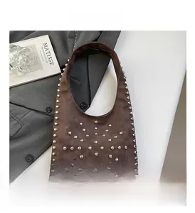 Detailed close-up of brown suede hobo bag with vintage silver metal rivet studs