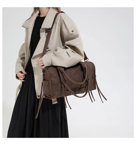 Detail of dark brown vintage wasteland tote bag with long fringe tassels on model