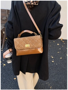 Detail of retro brown quilted crossbody bag with golden twist lock on stylish model