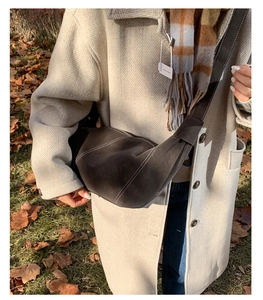 Detail of crescent crossbody bag in brown suede with contrast stitching and wide strap