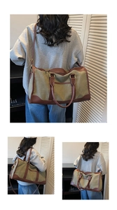 Detail view of large canvas travel bag with leather trim and adjustable shoulder strap