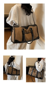Detail of a large canvas tote with leather trim showing handles and shoulder strap