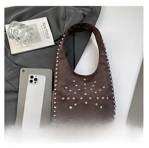 Detailed view of dark coffee suede tote with silver studs on the strap and body