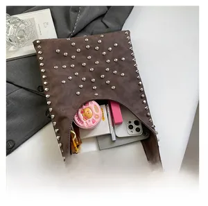 Interior capacity of brown vintage bucket bag showing phone and makeup items