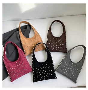 Détail de sacs seaux à rivets en cinq couleurs avec finition suède vintage