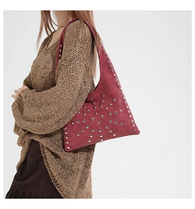 Detail view of dark red matte shoulder bag with silver rivet studs in retro rock style