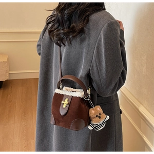 Brown suede bucket bag with white faux fur trim and cute bear charm shown on model