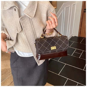 Detail shot of vintage quilted shoulder bag with contrast leather and gold twist lock