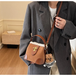 Brown faux suede bucket bag featuring white faux fur trim and a cute teddy bear pendant